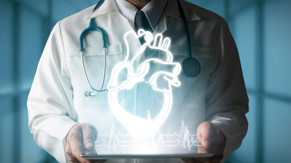 Doctor holding an illuminated iPad displaying a heart and heartbeat